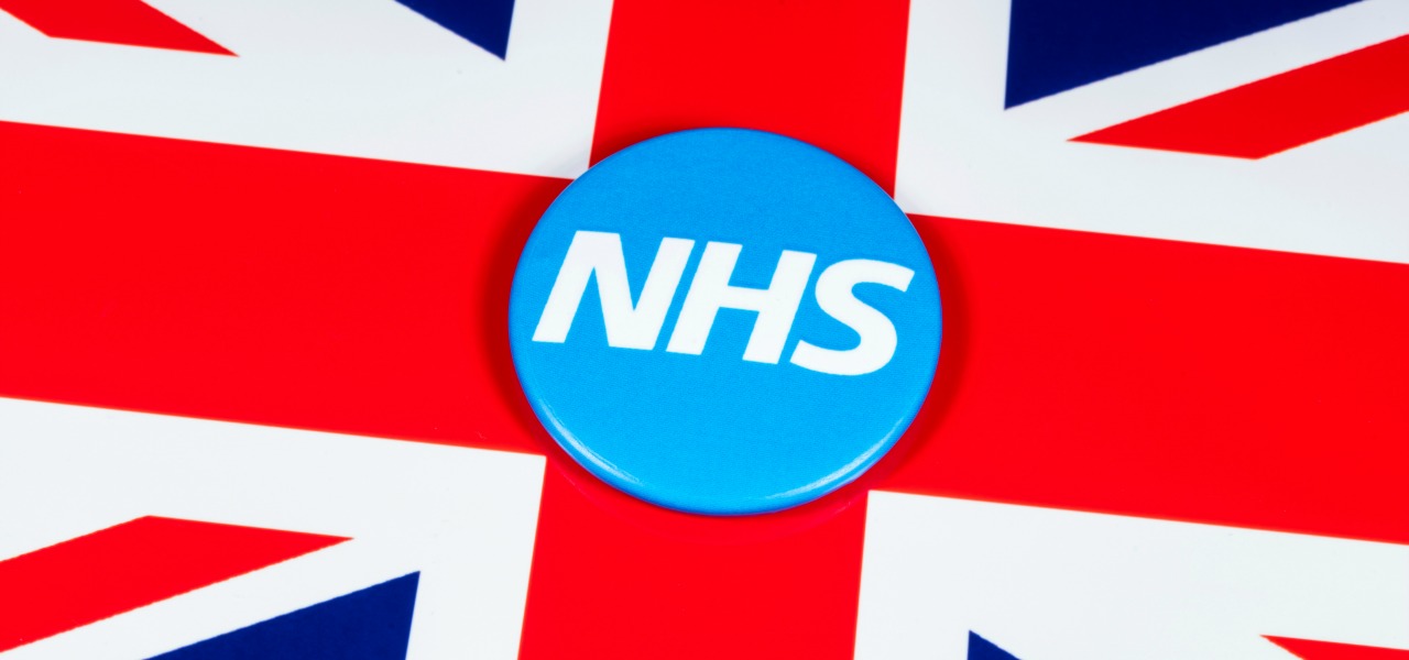 An NHS badge on top of the Union flag