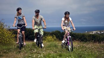 family cycling by the coast in cornwall