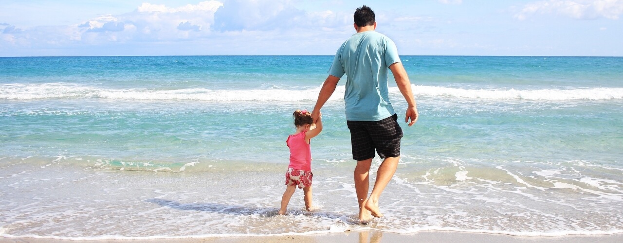 A father and daughter paddling in the sea