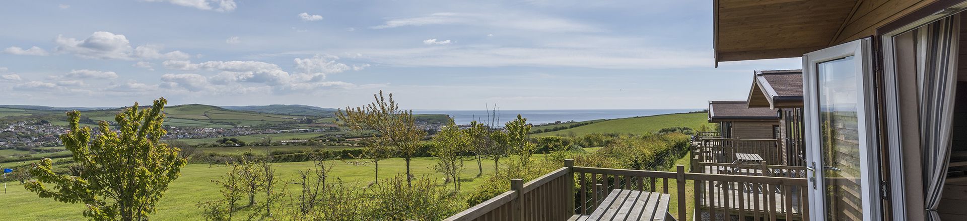 row of lodges with beautiful countryside and sea views at highlands end holiday park