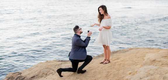 man proposing to woman on the beach