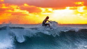 surfer riding the waves at sunset
