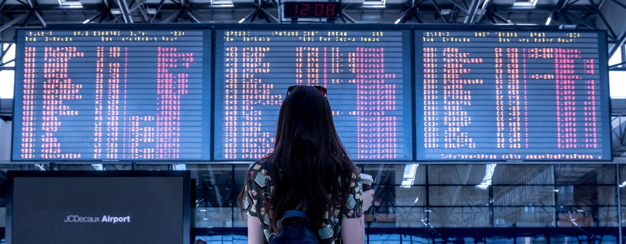Holidaymaker looking up at flight departure board